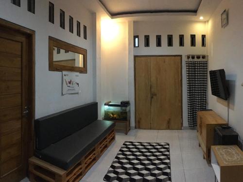 The G House Ambarrukmo في بانتول: غرفة معيشة مع أريكة وحوض أسماك