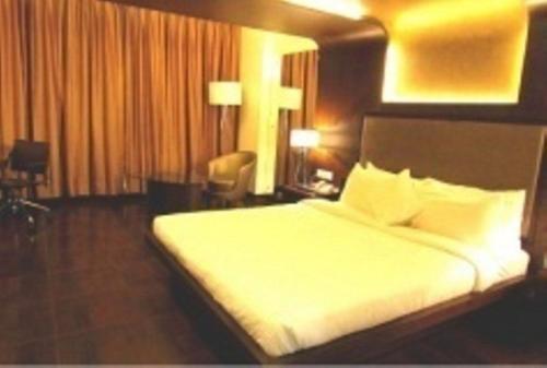 a hotel room with a bed in a room at Cocoon Luxury Business Hotel in Dhanbād
