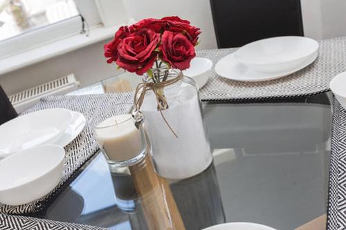 a red rose in a vase on a table with a candle at Derby Street City Centre Preston Aparthotel in Preston