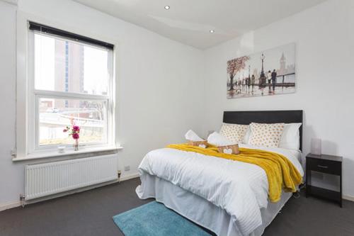 a white bedroom with a bed and a window at Derby Street City Centre Preston Aparthotel in Preston