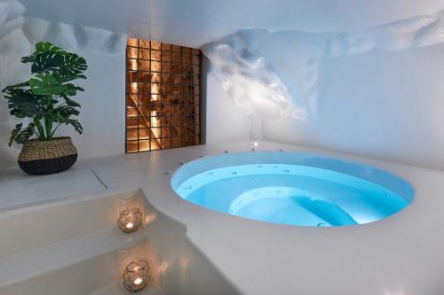 a bath room with a tub and a pool at Winery Hotel 1870 in Fira
