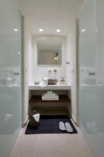 a bathroom with a sink and a mirror at Winery Hotel 1870 in Fira