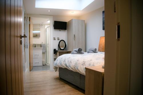 a bedroom with a bed and a bathroom with a sink at Eske Holiday Apartment in Donegal