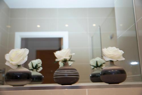 a row of vases with flowers in them on a shelf at Sunshine Place in Enfield
