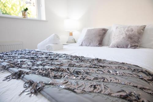 a white bed with a patterned blanket on it at Sunshine Place in Enfield