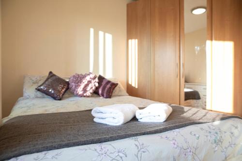a bedroom with a bed with towels on it at Tranquil Apartment with Stunning Views in Enfield