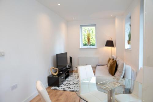 a living room with a glass table and a couch at Sunshine Place in Enfield