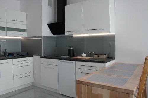 une cuisine avec des placards blancs et un comptoir dans l'établissement Apartament Miedzianka II, à Polkowice