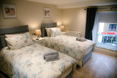 1 dormitorio con 2 camas y ventana en Eske Holiday Apartment, en Donegal