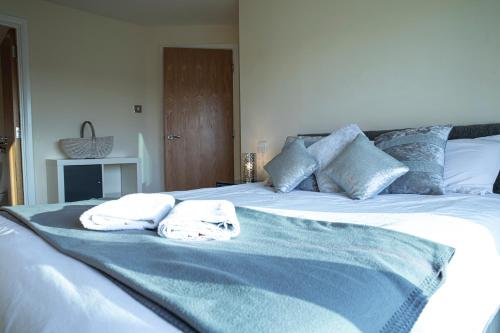 a bed with two towels sitting on top of it at Tranquil Apartment with Stunning Views in Enfield