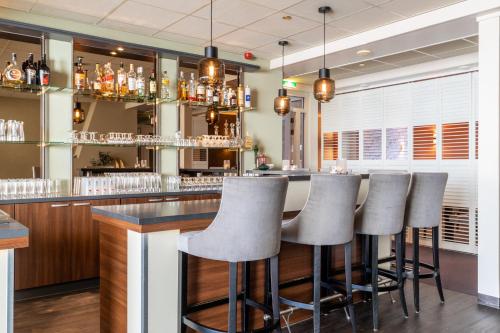 un bar con una fila de taburetes en un restaurante en Hotel Ameland en Nes