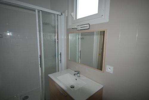 ein Bad mit einem Waschbecken, einer Dusche und einem Spiegel in der Unterkunft La réserve à bonheurs in Les Sables-dʼOlonne