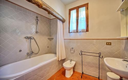 a bathroom with a tub and a toilet and a sink at Agriturismo Fattoria Celle in Figline Valdarno
