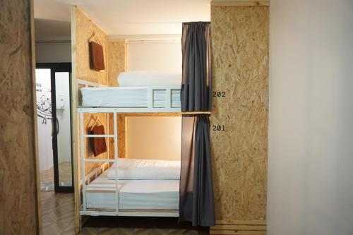 een kamer met een stapelbed met witte bedden bij Khoksametchun Hostel in Hat Yai