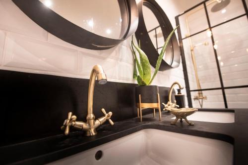 een wastafel in de badkamer met 2 kranen en een spiegel bij Ca n'Alorda Holiday Home Cala Llombards piscina, wifi, seguridad y relax in Santanyi