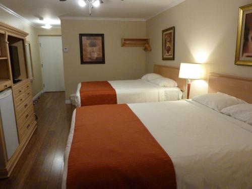a hotel room with two beds and a television at Motel Becancour in Bécancour