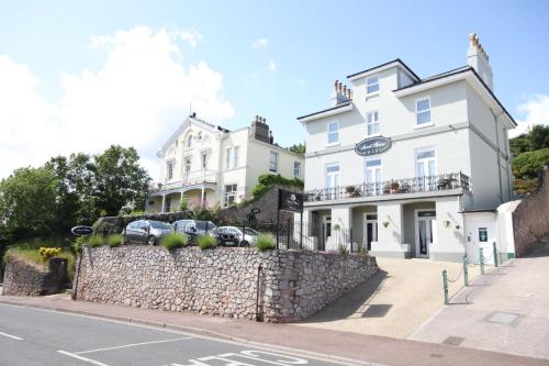 a white building with cars parked in front of it at Ascot House Hotel in Torquay