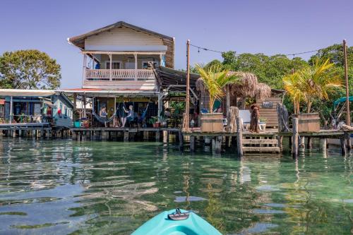 a house on a dock with a boat in the water at Barrbra BnB Over The Sea in Bocas del Toro
