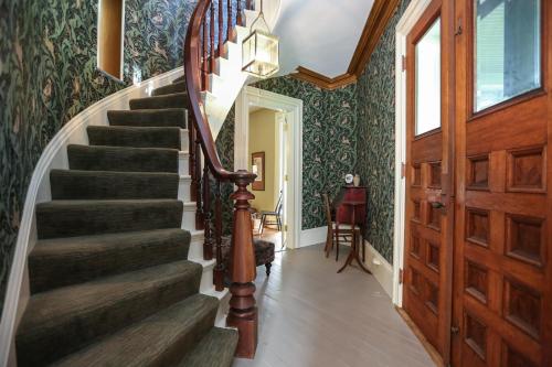 a staircase in a home with green wallpaper at Black Sheep Inn and Spa in Hammondsport