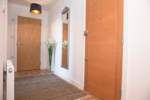 a hallway with a door and a vase of flowers at Sunshine Place in Enfield