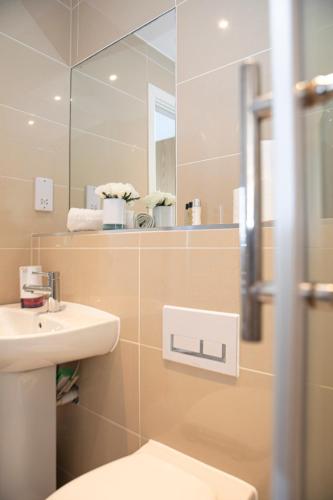 a bathroom with a sink and a mirror at Sunshine Place in Enfield