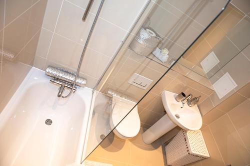 a bathroom with a shower and a toilet and a sink at Sunshine Place in Enfield