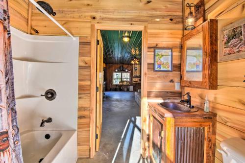 a bathroom with wooden walls and a tub and a sink at Avalon Woods Riverfront Retreat Walk to Waterfall in Marble