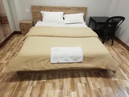 een slaapkamer met 2 bedden en een houten vloer bij Manaslu Homestay in Kathmandu