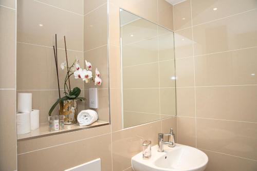 a bathroom with a sink and a mirror at Sunshine Place in Enfield