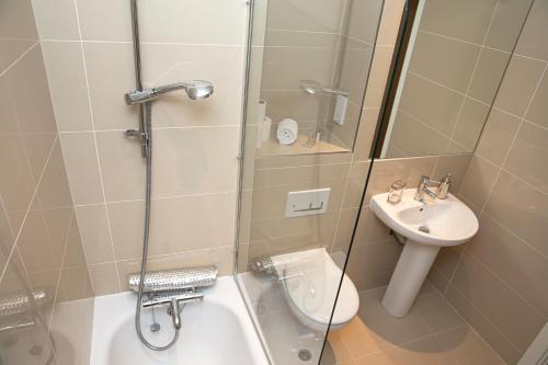 a bathroom with a shower and a toilet and a sink at Sunshine Place in Enfield