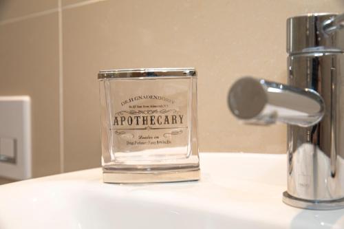 a glass container sitting on top of a bathroom sink at Sunshine Place in Enfield