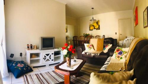 uma sala de estar com um sofá e uma TV em Apartamento 3Q - 310 - Meia Praia - Itapema - Verão 2026 em Itapema