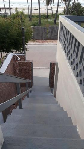 a stairway with benches and the beach in the background at Pousada Aconchego in Mundaú