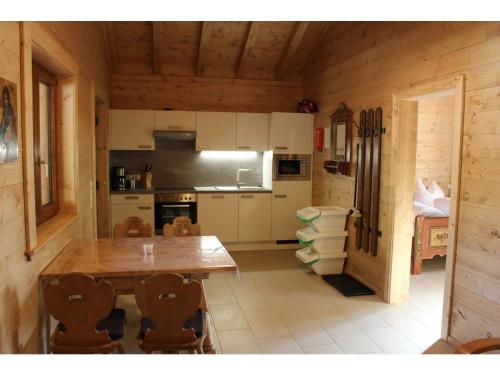 a kitchen with a wooden table in a cabin at Feriendorf X-Alp Lodges Ötztal in Sautens