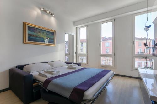 - une chambre avec un lit dans une pièce dotée de fenêtres dans l'établissement Casa da Suite Idea, à Milan