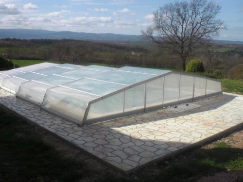 a large glass greenhouse on a stone patio at chambres d'hôtes de la colline in Chenay-le-Châtel