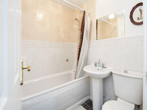 ein Badezimmer mit einem Waschbecken, einem WC und einer Badewanne in der Unterkunft My-Places Abbotsfield Court Townhouse 4 in Manchester