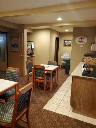 a waiting room at a hospital with tables and chairs at Super 8 by Wyndham Blue Earth in Blue Earth