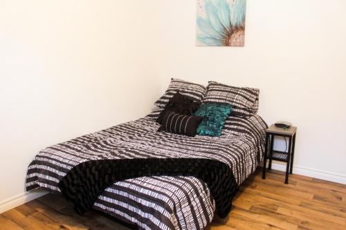 ein Bett mit einer schwarzen und weißen Decke und Kissen in der Unterkunft Casa Linda Victoriaville in Princeville