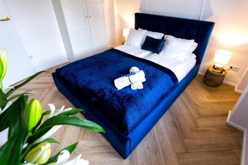 ein Schlafzimmer mit einem blauen Bett mit einem Teddybär darauf in der Unterkunft Apartament BIANCO BLU pod Jasną Górą. in Częstochowa