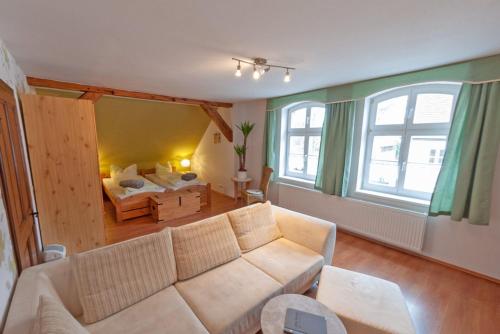 a living room with a couch and a bed at Alte Schule Café und Pension in Fürstlich Drehna