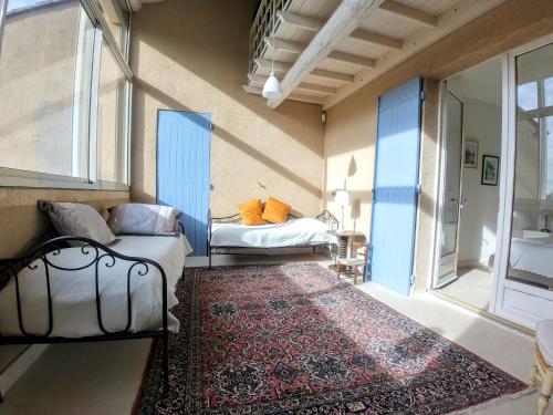 Cette petite chambre comprend 2 lits et un tapis. dans l'établissement Le Moulin de Felix, à Robion