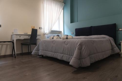 a bedroom with a bed with a desk and a chair at Maison Gentile in Lucca