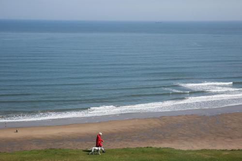 a person walking a dog on the beach at The Seacliffe - Whitby in Whitby