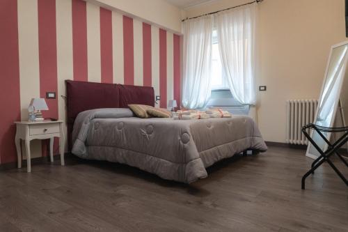 a bedroom with a bed and a striped wall at Maison Gentile in Lucca
