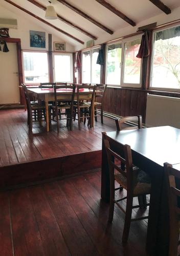 a dining room with tables and chairs and windows at Pensiunea Gernik 100 in Gârnic