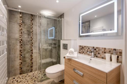 a bathroom with a shower and a toilet and a sink at Maison Amande in La Flotte