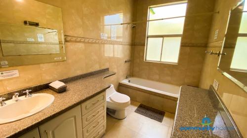 a bathroom with a sink and a toilet and a mirror at Community Hostel Quito in Quito