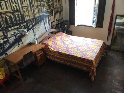 a bedroom with a bed and a desk and a window at Charme do Poço in Recife
