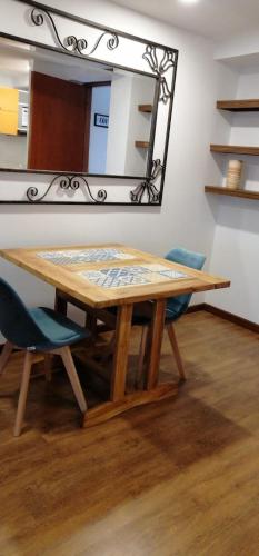 a wooden table with two chairs and a mirror at 100 Wonderful House in Bogotá